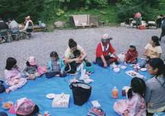 サッポロシニア-yyyymmdd_シニア農園の収穫祭_札幌育児園の園児と車座になってジンギスカンを食べる